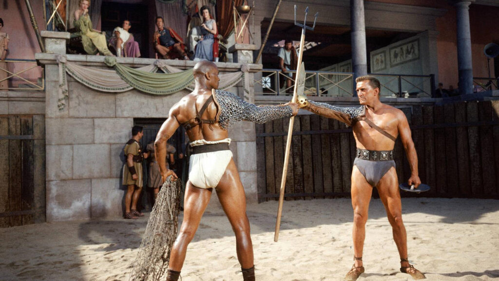 An image of Kirk Douglas as Spartacus and Woody Strode as Draba battling in a gladiator arena in the 1960 film Spartacus.