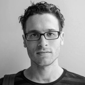 IsaakLiptzin_Headshot A headshot of cinematographer Isaak Liptzin. He is shot in black and white against a neutral background, and wears glasses and a dark shirt.